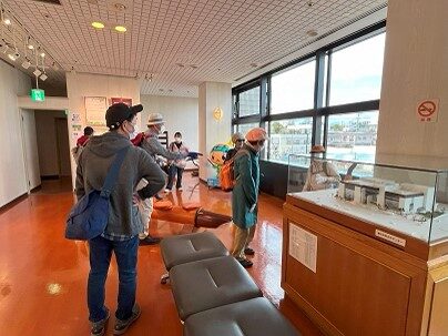 ⑦　文化センター２階の「楽都こおりやま」紹介コーナーを案内する学生